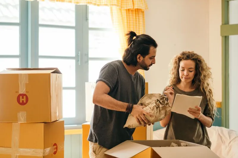 Jong stel pakt samen verhuisdozen uit in hun nieuwe woning